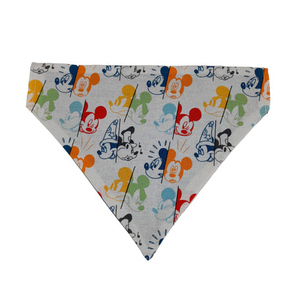 A triangular pet bandana featuring a colorful cartoon Mickey mouse pattern on a light gray background, laid flat on a neutral off-white surface.