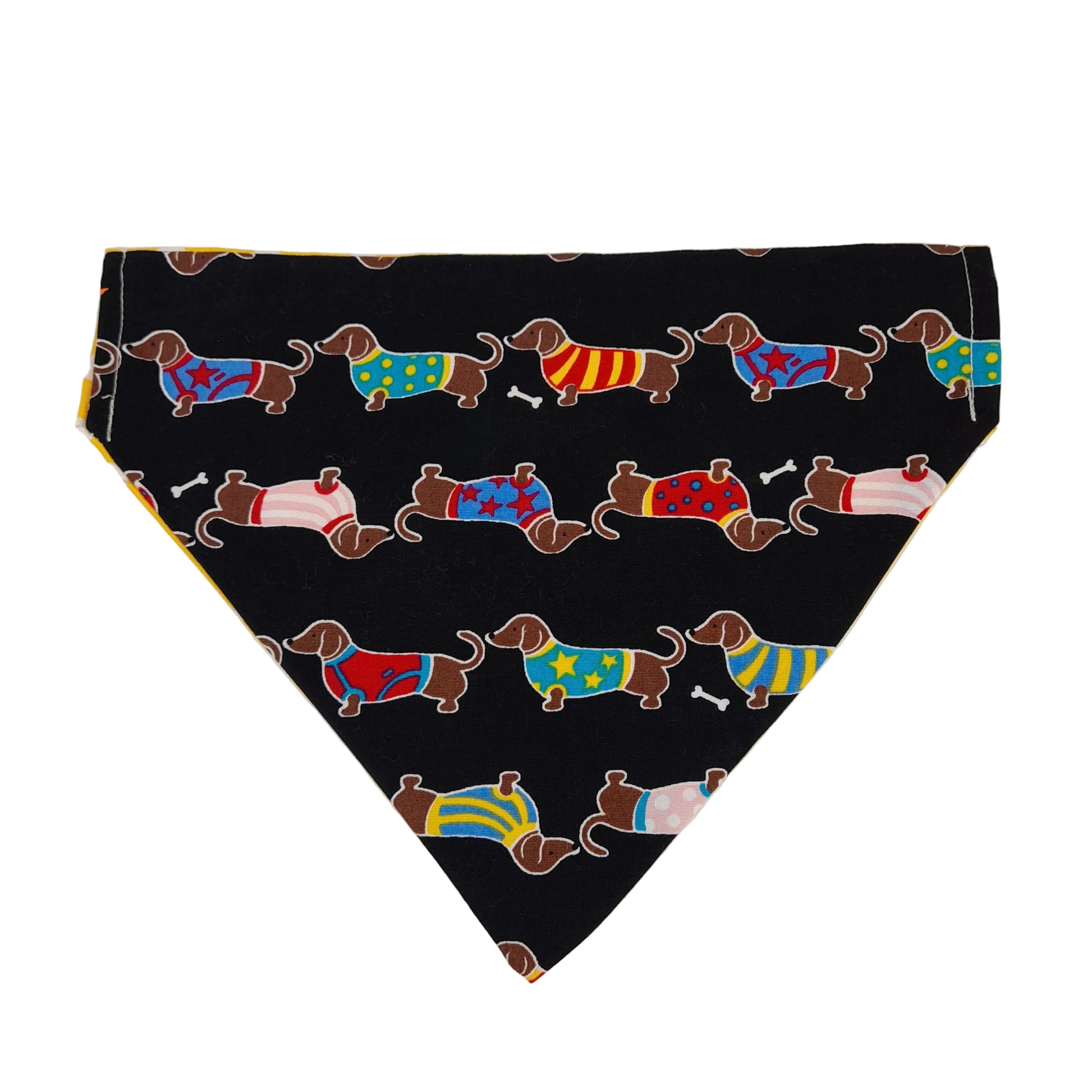A triangular pet bandana or scarf laid flat on a light background, featuring a black base with a repeating pattern of dachshund dogs wearing colorful sweaters.
